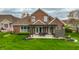 Aerial view of a brick house with a patio leading to a spacious, well-kept green lawn at 6049 Royal Gate Pl, Indianapolis, IN 46237