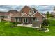 Aerial view of a brick house with a covered patio extending to a spacious backyard at 6049 Royal Gate Pl, Indianapolis, IN 46237