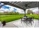 Covered backyard patio with a dining table and well-manicured yard at 6049 Royal Gate Pl, Indianapolis, IN 46237