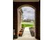 View from brick arch looking out onto a green lawn, walkway, and pond at 6049 Royal Gate Pl, Indianapolis, IN 46237
