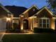 Charming brick home with a manicured lawn and professional landscape lighting for evening appeal at 6049 Royal Gate Pl, Indianapolis, IN 46237