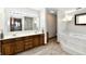 Bright bathroom features a double vanity with wood cabinets, a large mirror, and a separate soaking tub at 611 Mill Farm Rd, Noblesville, IN 46062