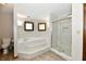 This bathroom features a tiled walk-in shower with glass doors, a soaking tub, and two windows at 611 Mill Farm Rd, Noblesville, IN 46062