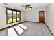 This bedroom has a ceiling fan, a neutral carpet, a closet, and a large window overlooking the yard at 611 Mill Farm Rd, Noblesville, IN 46062