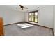 This bedroom has a ceiling fan, a neutral carpet, and a large window that provides an abundance of light at 611 Mill Farm Rd, Noblesville, IN 46062