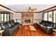 Spacious living room with hardwood floors, a brick fireplace, and comfortable seating arrangement at 611 Mill Farm Rd, Noblesville, IN 46062