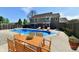 Backyard pool with lounge chairs, a wooden dining set, and a privacy fence at 611 Mill Farm Rd, Noblesville, IN 46062