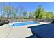 Private backyard pool surrounded by a concrete patio and wood fence at 611 Mill Farm Rd, Noblesville, IN 46062