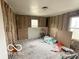 Bedroom with exposed insulation, windows and a pile of boards on the floor at 629 E 32Nd St, Anderson, IN 46016