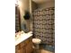 Well-maintained bathroom with unique shower curtain and ample storage at 6525 Emerald Hill Ct # 208, Indianapolis, IN 46237