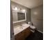 Bathroom with bright lighting, laminate floors, and an eye-catching mirror at 6525 Emerald Hill Ct # 208, Indianapolis, IN 46237
