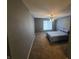 A carpeted bedroom with a ceiling fan and neutral color scheme, featuring a blue bedset at 6525 Emerald Hill Ct # 208, Indianapolis, IN 46237