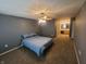 This bedroom features neutral walls, carpeted floors, a ceiling fan with lights, and an attached bathroom at 6525 Emerald Hill Ct # 208, Indianapolis, IN 46237