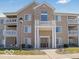 Inviting condo exterior featuring balconies, tan siding, and a prominent entrance with stone accents at 6525 Emerald Hill Ct # 208, Indianapolis, IN 46237