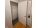 Hallway showing a carpeted closet with wire shelving to the left of a solid white door at 6525 Emerald Hill Ct # 208, Indianapolis, IN 46237