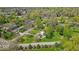 This aerial view showcases a charming home with a lush green lawn nestled among mature trees in a quiet neighborhood at 7205 Steven Ln, Indianapolis, IN 46260