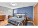 Bedroom features a blue accent wall, hardwood floors, and built-in closet at 7205 Steven Ln, Indianapolis, IN 46260