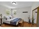 Bright bedroom with hardwood floors, neutral walls, natural light, and a decorative mirror at 7205 Steven Ln, Indianapolis, IN 46260