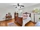 Charming bedroom featuring hardwood floors, a ceiling fan and large window for natural light at 7205 Steven Ln, Indianapolis, IN 46260