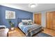 Bedroom features hardwood floors, natural light, a built-in closet, and blue accent wall at 7205 Steven Ln, Indianapolis, IN 46260