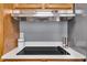 Close up of the electric cooktop with stylish backsplash and hood at 7205 Steven Ln, Indianapolis, IN 46260