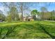 Expansive front yard featuring lush greenery and mature trees surrounding a well-maintained home with a private driveway at 7205 Steven Ln, Indianapolis, IN 46260