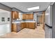 Bright kitchen featuring wood cabinets, stainless steel appliances, and an adjacent living area at 7205 Steven Ln, Indianapolis, IN 46260