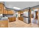 Traditional kitchen with wood cabinetry, stainless appliances, and wood-look flooring at 7205 Steven Ln, Indianapolis, IN 46260