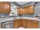 Kitchen featuring a window, stainless steel appliances, wood cabinets, and white countertops at 7205 Steven Ln, Indianapolis, IN 46260