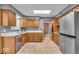 Bright kitchen with wood cabinets, stainless steel appliances, and wood-look flooring at 7205 Steven Ln, Indianapolis, IN 46260