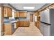 Functional kitchen with stainless steel fridge, wood cabinets, and modern appliances at 7205 Steven Ln, Indianapolis, IN 46260