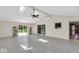 Spacious living room featuring skylights, neutral decor, and multiple access points to the backyard at 7205 Steven Ln, Indianapolis, IN 46260