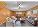 Inviting living room featuring cozy seating, natural light, and wood-paneled walls at 7205 Steven Ln, Indianapolis, IN 46260