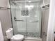 Updated bathroom features a tiled shower, modern fixtures, and toilet, and glass door at 7440 S 250 W, Pendleton, IN 46064