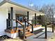 Inviting covered porch with stained wood trim, gray decking, and a modern cable railing system at 7440 S 250 W, Pendleton, IN 46064