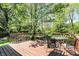 Back deck featuring a table and seating, overlooking a large, wooded yard at 7728 Mallard Way, Indianapolis, IN 46256