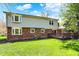 View of the back of this two-story home with a wooden deck overlooking the large backyard lawn and garden at 7728 Mallard Way, Indianapolis, IN 46256