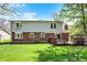View of the brick and vinyl siding of the back of this home with a wooden deck and large, well-maintained lawn at 7728 Mallard Way, Indianapolis, IN 46256