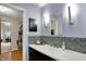 Bathroom vanity with mosaic backsplash, modern lighting, and access to a large walk-in closet at 7728 Mallard Way, Indianapolis, IN 46256