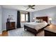 Cozy bedroom with hardwood floors, large window, ceiling fan, and neutral color scheme at 7728 Mallard Way, Indianapolis, IN 46256