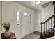 Bright foyer featuring decorative front door with glass panels, staircase, and stylish decor at 7728 Mallard Way, Indianapolis, IN 46256