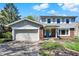 Charming two-story home featuring a blue front door, attached garage and manicured landscaping at 7728 Mallard Way, Indianapolis, IN 46256