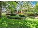 View of the backyard showcasing mature trees, landscaped beds and patio seating area at 8089 Lynch Ln, Indianapolis, IN 46250