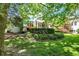 Large backyard showcasing mature trees, lush greenery, screened porch and stone patio at 8089 Lynch Ln, Indianapolis, IN 46250