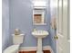 Stylish powder room featuring a classic pedestal sink and light blue walls at 8089 Lynch Ln, Indianapolis, IN 46250