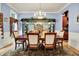 Formal dining room with a chandelier, decorative display cabinet, and seating for six around wooden table at 8089 Lynch Ln, Indianapolis, IN 46250