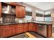 Updated kitchen with stainless steel appliances, a decorative backsplash, dark countertops and hardwood floors at 8089 Lynch Ln, Indianapolis, IN 46250