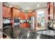 Well-equipped kitchen features stainless steel appliances and beautiful dark countertops with cherry wood cabinets at 8089 Lynch Ln, Indianapolis, IN 46250