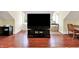 Spacious living area with a large TV, ample storage, natural light, and hardwood floors perfect for relaxing or working at 8089 Lynch Ln, Indianapolis, IN 46250