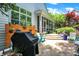 View of stone patio with outdoor kitchen, screened porch, and mature landscaping at 8089 Lynch Ln, Indianapolis, IN 46250